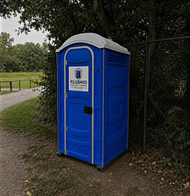 Blue standard portable toilet rental unit set beside a park path